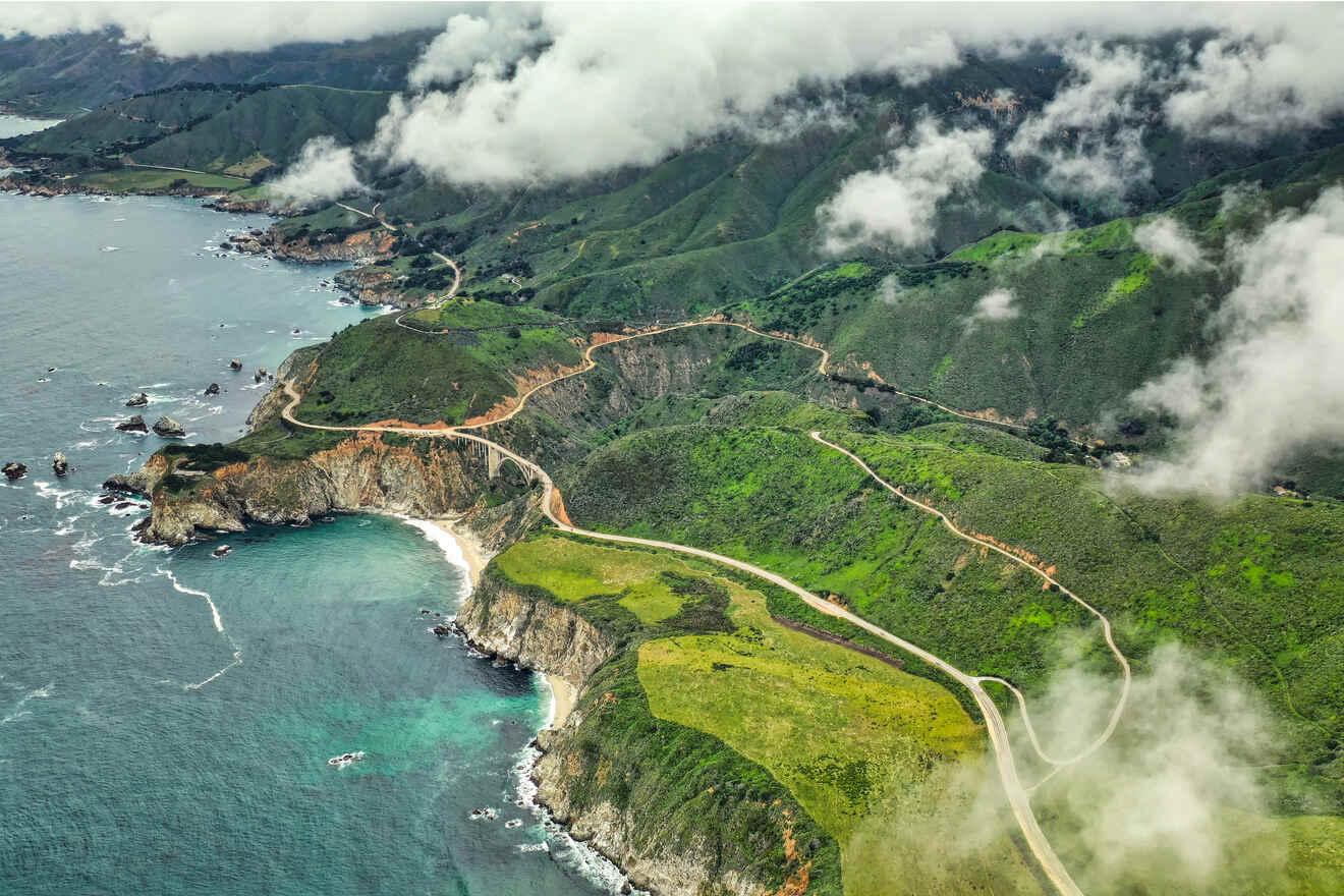 an aerial view of a winding road next to the ocean